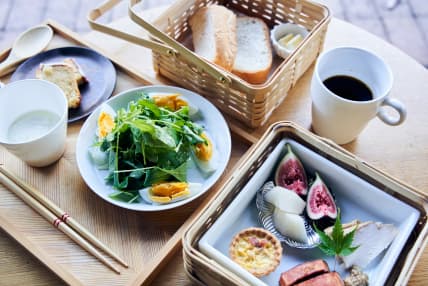 竹籠に入った厚切りのパンに新鮮な野菜がたっぷりのサラダ、無花果やキッシュなどボリューム満点の朝食